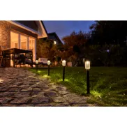 Jardín con lámpara solar iluminada