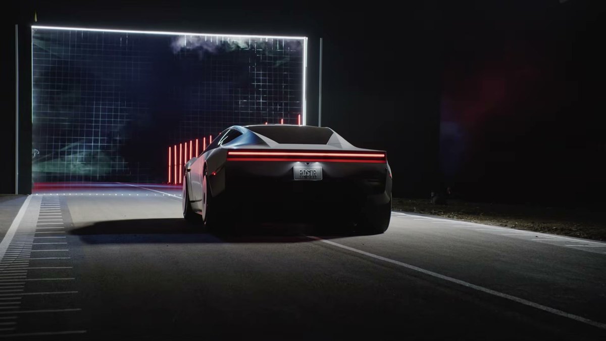 Tesla Roadster de espaldas con la matrícula RDSTR delante de una pantalla gigante