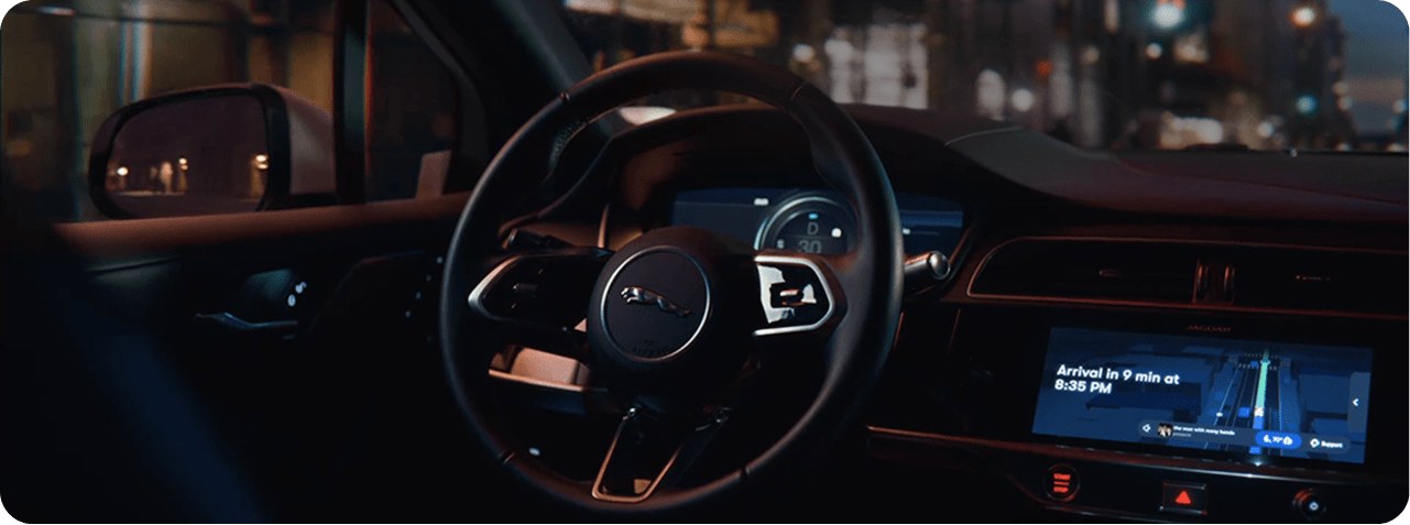 Interior del robotaxi de Waymo con el volante y la pantalla que muestra el tiempo de llegada