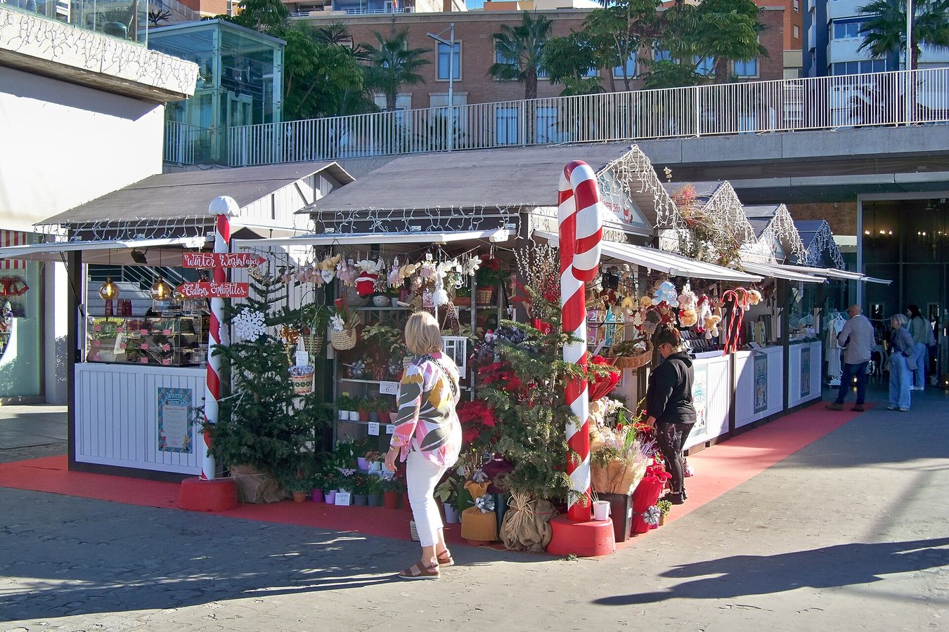 Casetas de madera blancas y rojas del mercadillo de Navidad del Muelle Uno de Málaga