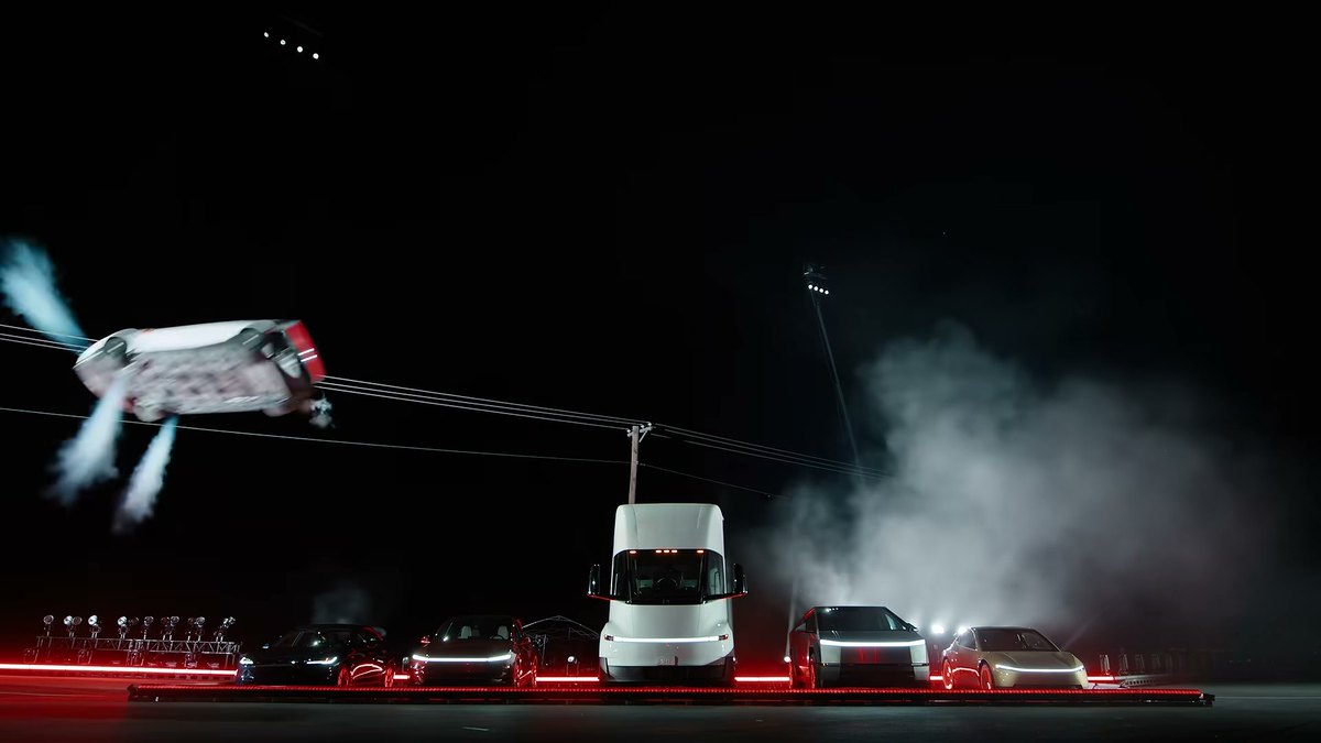 El Tesla Roadster en el aire con los propulsores encendidos sobre una fila de coches de Tesla